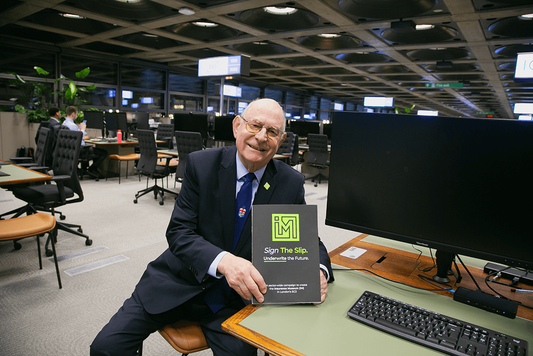 Reg Brown, IM Chairman, holding The Slip in an underwriting room
